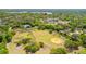 Expansive aerial view showcasing neighborhood park, school, and beautiful tree coverage with a community lake in the distance at 3310 Valencia Rd, Tampa, FL 33618