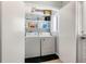 Bright laundry room featuring a washer, dryer, and shelving for storage at 3310 Valencia Rd, Tampa, FL 33618