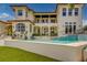 Luxurious home backyard with outdoor dining and seating area, leading to a pool with turf at 362 41St Ave, St Pete Beach, FL 33706