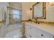 Stylish bathroom featuring a vanity with a framed mirror, decorative sconces, and a tiled tub-shower combo at 362 41St Ave, St Pete Beach, FL 33706