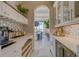 Bright butler pantry boasts quartz countertops, beverage center, stylish backsplash and views into the dining room at 362 41St Ave, St Pete Beach, FL 33706