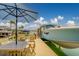 Waterfront dock with boat lift, outdoor seating, and an umbrella for shade at 362 41St Ave, St Pete Beach, FL 33706