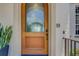 View of wood grain front door with an arched window pane and digital lock at 362 41St Ave, St Pete Beach, FL 33706