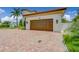 Attached two-car garage featuring paneled doors and exterior sconces, complemented by a brick-paved driveway at 362 41St Ave, St Pete Beach, FL 33706