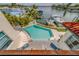 A backyard pool overlooks a waterfront with docks, boats, and lounge chairs in this luxury real estate listing at 362 41St Ave, St Pete Beach, FL 33706