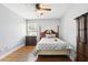 This cozy bedroom features hardwood floors, a ceiling fan, and a warm, inviting atmosphere at 3802 Cloverhill Ct, Brandon, FL 33511