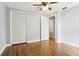 Vacant bedroom with hardwood floors, ceiling fan, closet, and access to an adjacent room at 3802 Cloverhill Ct, Brandon, FL 33511