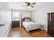 This charming bedroom features hardwood floors, a ceiling fan, and a warm, cozy atmosphere at 3802 Cloverhill Ct, Brandon, FL 33511