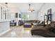 Spacious living room featuring a large sectional sofa, tile flooring, and a ceiling fan at 3802 Cloverhill Ct, Brandon, FL 33511