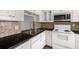 Cozy kitchen with white appliances, cabinets, dark countertops and stainless steel faucet at 4227 Glissade Dr, New Port Richey, FL 34652