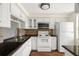Functional kitchen features white appliances, cabinets, and a stylish backsplash, complemented by dark countertops at 4227 Glissade Dr, New Port Richey, FL 34652