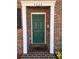 Close-up of a green front door with white trim and brick surround, creating a welcoming entrance at 4624 W North B St, Tampa, FL 33609