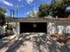 Exterior view of the garage with an open door and shade from a tree at 4624 W North B St, Tampa, FL 33609