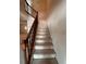 A staircase with carpeted steps and dark wood banister leads to the upper level of the home at 4624 W North B St, Tampa, FL 33609