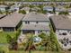 Backyard with outdoor grill, plus patio seating and palm trees in a fenced yard with lake community beyond at 4777 Ballantrae Blvd, Land O Lakes, FL 34638