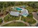 An aerial view showcases the community pool and swim club, surrounded by lush landscaping and trees at 4777 Ballantrae Blvd, Land O Lakes, FL 34638