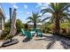 Beautifully landscaped backyard patio with outdoor seating, tropical plants, and a serene water view at 4777 Ballantrae Blvd, Land O Lakes, FL 34638