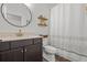 Bright bathroom with a modern vanity, round mirror, decorative shelves and a patterned shower curtain at 4777 Ballantrae Blvd, Land O Lakes, FL 34638