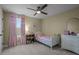 Bright bedroom with a twin bed, a bookshelf, a small dresser, and pink ruffle curtains at 4777 Ballantrae Blvd, Land O Lakes, FL 34638