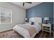 Comfortable bedroom with a plush bed, stylish nightstands, a blue accent wall, and a window view at 4777 Ballantrae Blvd, Land O Lakes, FL 34638