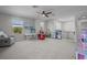 Spacious bonus room with multiple windows, ceiling fan, and play area with table and toy kitchen at 4777 Ballantrae Blvd, Land O Lakes, FL 34638