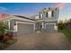Beautiful home with a three car garage and a brick paved driveway at sunset at 4777 Ballantrae Blvd, Land O Lakes, FL 34638