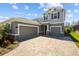 Charming two-story home showcasing a three-car garage, brick accents, and a well-manicured front yard at 4777 Ballantrae Blvd, Land O Lakes, FL 34638