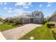 Two-story home featuring a 3-car garage, gray siding, and beautiful landscaping at 4777 Ballantrae Blvd, Land O Lakes, FL 34638
