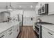 Well-lit kitchen featuring white cabinetry, subway tile backsplash, stainless steel appliances, and a large island at 4777 Ballantrae Blvd, Land O Lakes, FL 34638