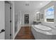 Bright main bathroom with a soaking tub, glass shower, walk-in closet, and wood-look flooring at 4777 Ballantrae Blvd, Land O Lakes, FL 34638