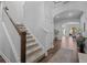 Elegant staircase featuring wood accents, white risers and a view into the expansive living area at 4777 Ballantrae Blvd, Land O Lakes, FL 34638