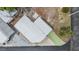 Aerial view of a bright home with a white roof, green driveway, gravel landscaping, and surrounding neighborhood at 4851 W Gandy Blvd # B4L38, Tampa, FL 33611
