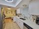 Modern kitchen with white cabinets, stainless steel appliances, and a view of the well lit living area at 523 Oakbriar Pl, Brandon, FL 33510