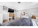 Well-lit bedroom offering a mounted TV, storage baskets, a dresser, and a neutral gray rug at 615 10Th Ne Ave # 1, St Petersburg, FL 33701