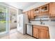 Well lit kitchen featuring a white refrigerator, stainless dishwasher, and wood cabinets at 615 10Th Ne Ave # 1, St Petersburg, FL 33701