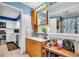 Well-lit bathroom featuring a wooden vanity, ample counter space, and a door leading to an adjacent kitchen at 753 Almeda N St, St Petersburg, FL 33702