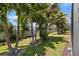 Green backyard showcasing mature trees, tropical landscaping and a white fence for privacy at 8078 Pine Crest St, Seminole, FL 33777