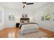 Bedroom featuring hardwood floors, a ceiling fan, and large windows with shutters at 8078 Pine Crest St, Seminole, FL 33777