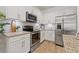 Bright kitchen features stainless steel appliances, granite countertops, and white cabinets at 8078 Pine Crest St, Seminole, FL 33777