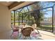 Relaxing screened in patio with a glass table, four chairs, and views of the yard at 8078 Pine Crest St, Seminole, FL 33777