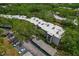 Aerial view of the condo complex surrounded by lush trees, showcasing the parking at 870 Virginia St # 109, Dunedin, FL 34698
