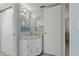 Bright bathroom featuring stylish vanity with a round mirror and decorative lighting at 870 Virginia St # 109, Dunedin, FL 34698