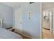 Bright bedroom leading to a bathroom with a stylish vanity and round mirror at 870 Virginia St # 109, Dunedin, FL 34698