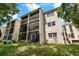 Well-maintained building featuring screened patios and lush green landscaping at 870 Virginia St # 109, Dunedin, FL 34698