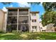 Exterior view of the building with screened patios and beautiful landscaping at 870 Virginia St # 109, Dunedin, FL 34698