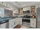 Condo kitchen featuring stainless steel appliances, white cabinets and an open layout with a view of the sink at 870 Virginia St # 109, Dunedin, FL 34698