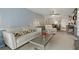 Open-concept living room flowing into the dining area, featuring neutral tones and comfortable furniture at 870 Virginia St # 109, Dunedin, FL 34698