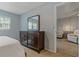 Spacious main bedroom featuring a dresser with a mirror and a glimpse of the adjacent living area at 870 Virginia St # 109, Dunedin, FL 34698