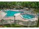 Community pool with an attached spa, surrounded by lounge chairs and lush greenery at 870 Virginia St # 109, Dunedin, FL 34698