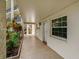 Exterior walkway leading to a condo unit featuring a well-lit entrance, garden bed, and a view of the building at 870 Virginia St # 109, Dunedin, FL 34698